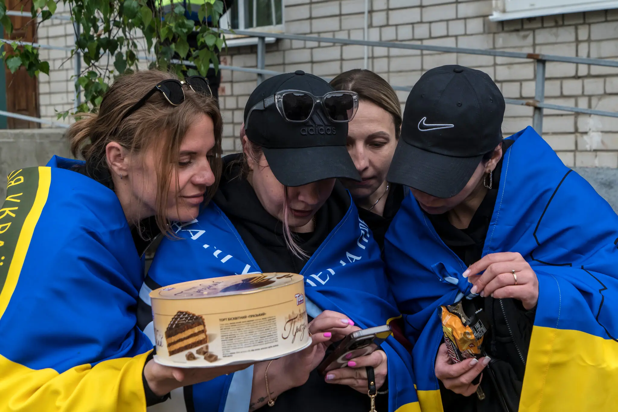 Анастасія Добрєва (ліворуч) та її сестра Інга Паламарчук (друга праворуч) чекають на свого брата Юрія Добрєва, військовослужбовця Національної гвардії України, який перебуває у полоні в Росії.